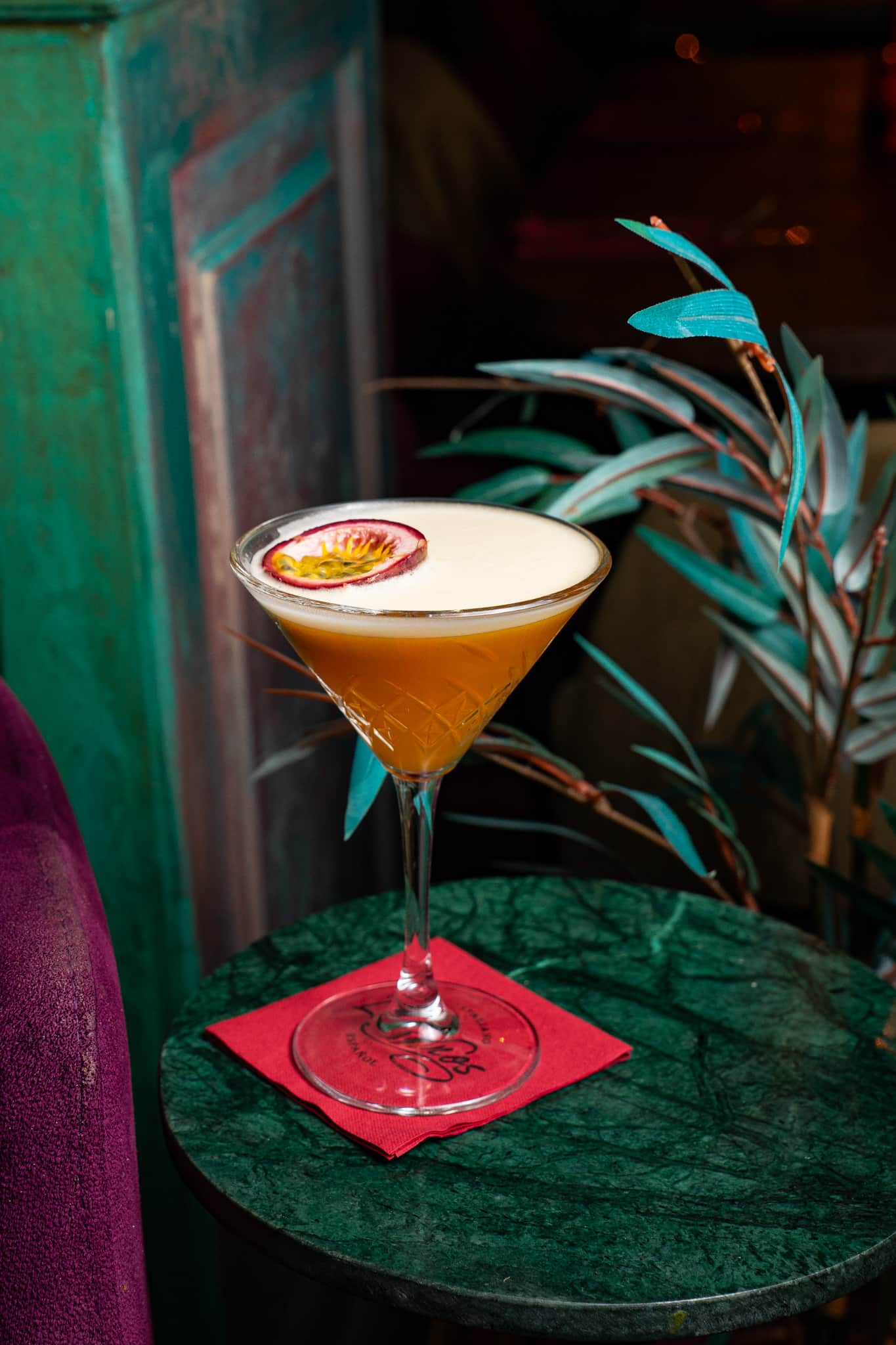 Passievrucht-martini op een groenmarmeren tafeltje bij Latinos