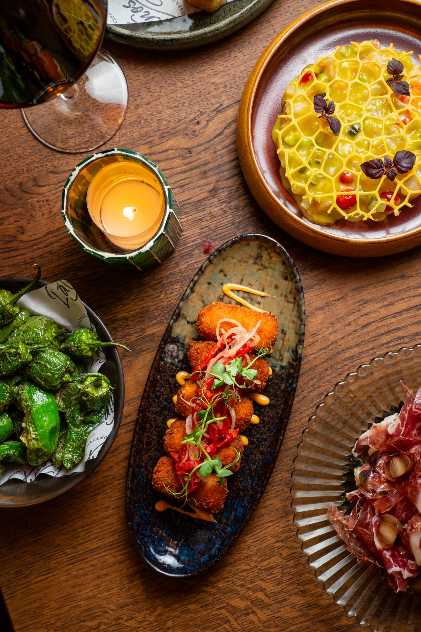 Gedeelde tapas met padrón-pepers en candlelight